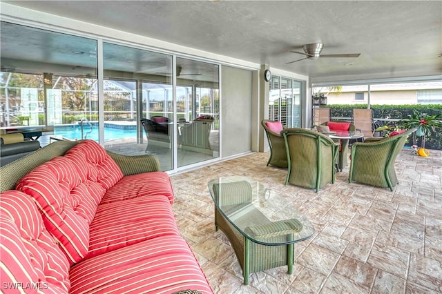 sunroom featuring ceiling fan and plenty of natural light