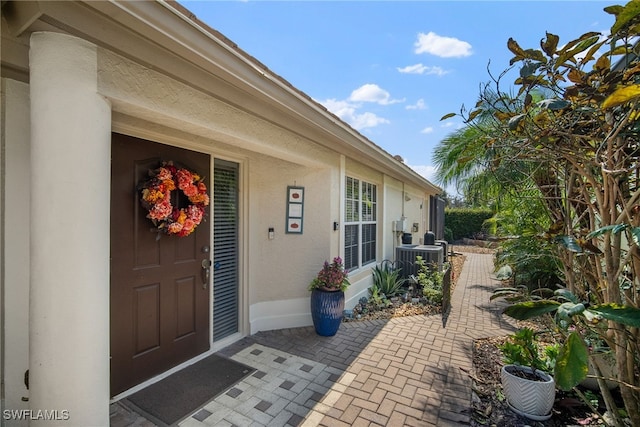 doorway to property featuring cooling unit and a patio