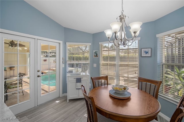 dining area featuring light hardwood / wood-style floors, french doors, a chandelier, and lofted ceiling