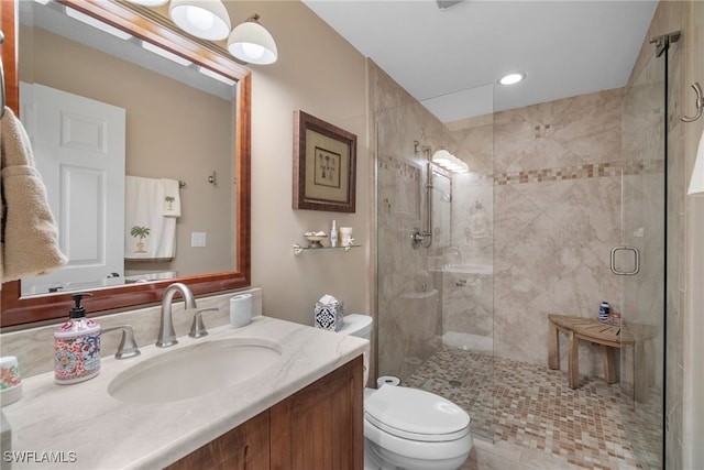 bathroom with toilet, an enclosed shower, and vanity