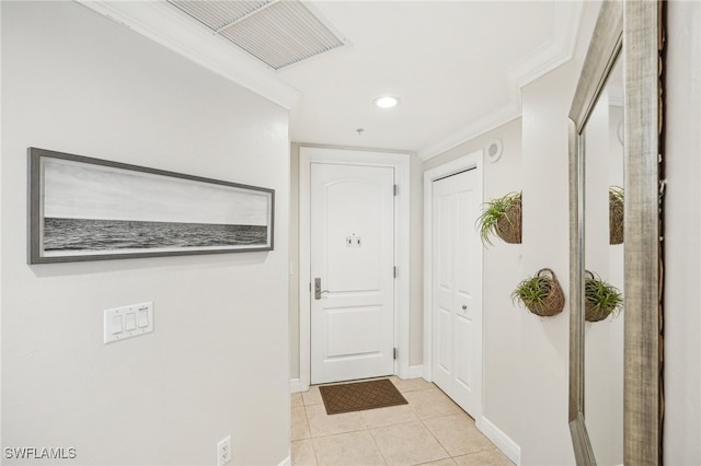 doorway to outside with crown molding and light tile patterned floors