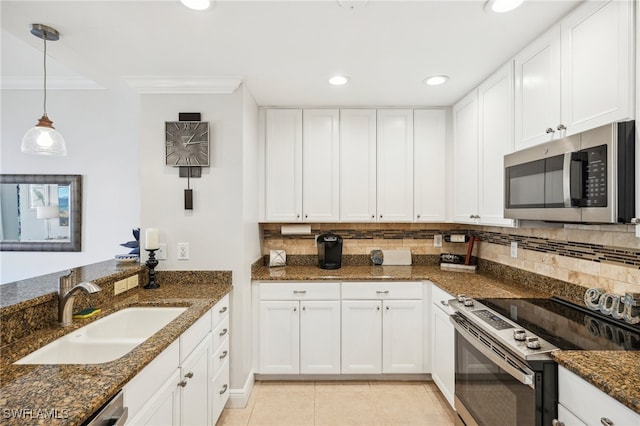 kitchen featuring appliances with stainless steel finishes, white cabinetry, and dark stone counters