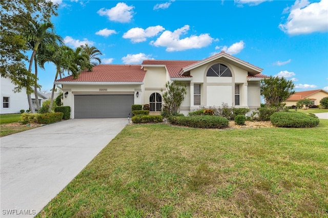 mediterranean / spanish house featuring a front lawn and a garage