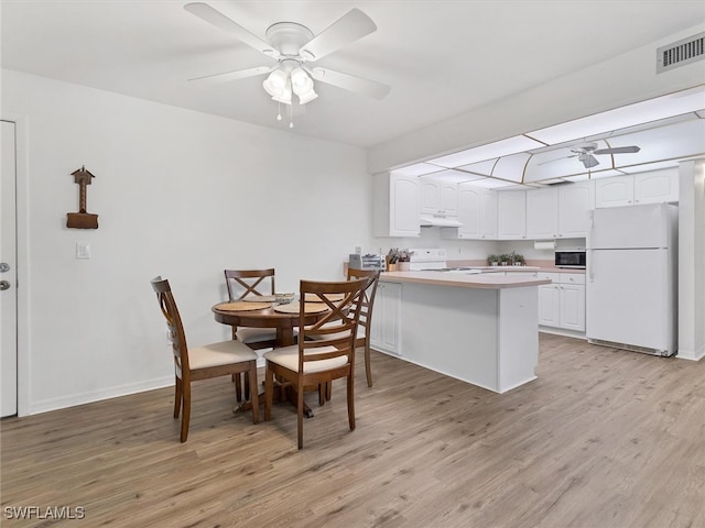 dining space with light hardwood / wood-style floors and ceiling fan