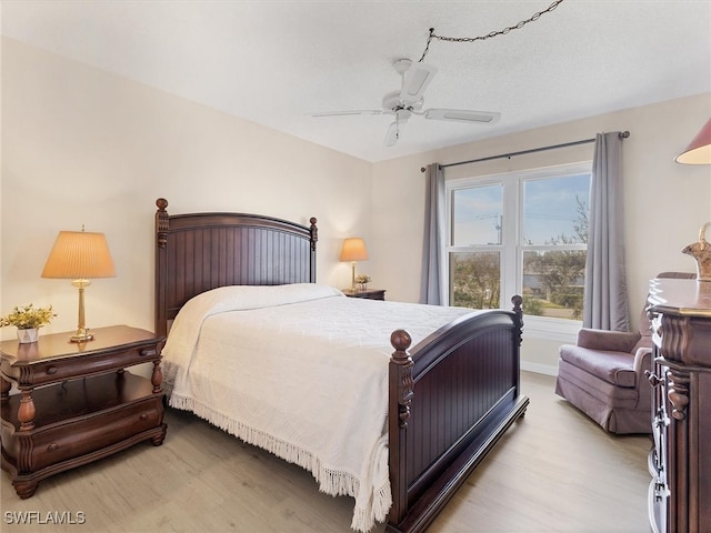 bedroom featuring ceiling fan, a textured ceiling, and light hardwood / wood-style flooring