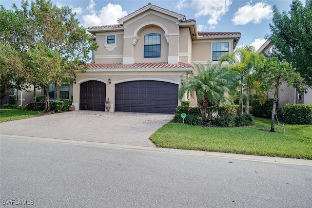 mediterranean / spanish house featuring a front lawn and a garage