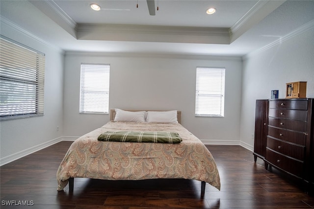 bedroom with ornamental molding, a tray ceiling, and dark hardwood / wood-style flooring