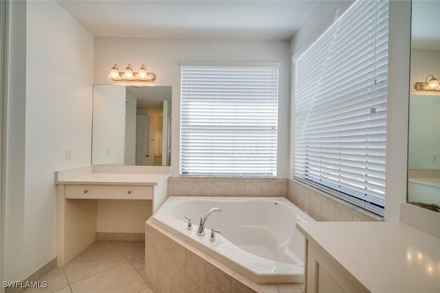 bathroom with a wealth of natural light, vanity, tiled tub, and tile patterned flooring