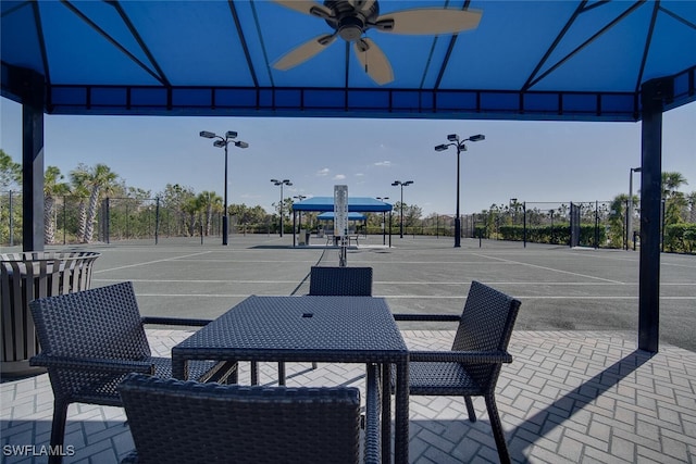 view of patio / terrace featuring tennis court and ceiling fan