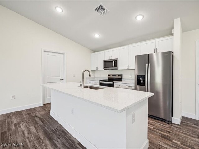 kitchen with white cabinetry, stainless steel appliances, sink, and an island with sink