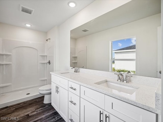 bathroom with toilet, walk in shower, vanity, and wood-type flooring