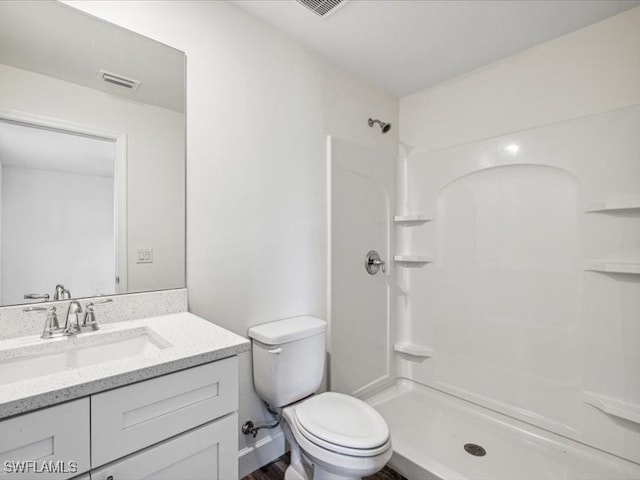 bathroom featuring vanity, toilet, and a shower