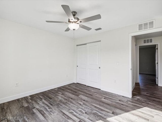 unfurnished bedroom with a closet, dark hardwood / wood-style floors, and ceiling fan