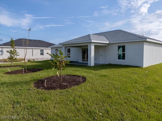 rear view of property featuring a lawn