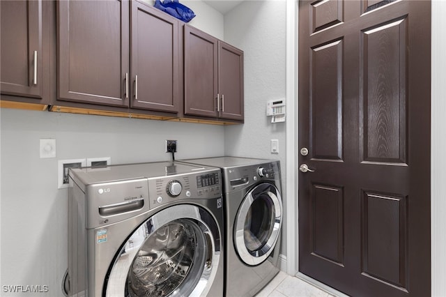 washroom featuring light tile patterned flooring, independent washer and dryer, and cabinets