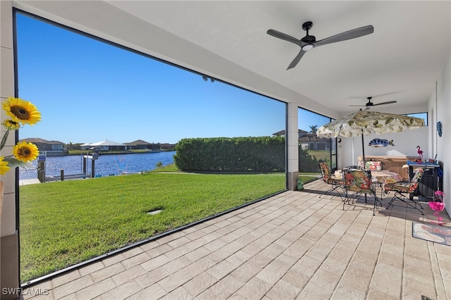 sunroom / solarium featuring a water view and ceiling fan