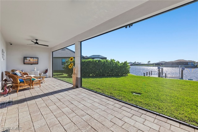 unfurnished sunroom with a water view and ceiling fan