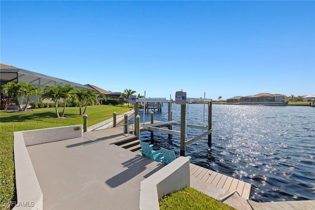 view of dock with a water view, a lawn, and a lanai