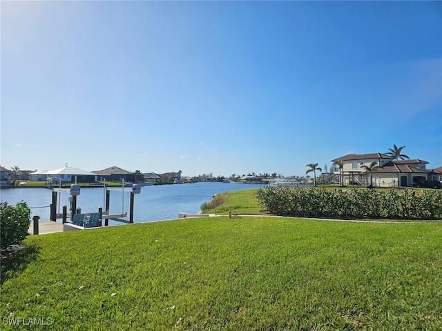 view of yard with a water view and a boat dock