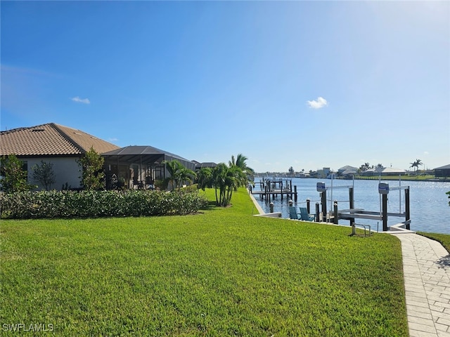 dock area with a water view, a lawn, and a lanai