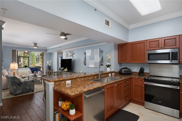 kitchen featuring kitchen peninsula, appliances with stainless steel finishes, sink, and light wood-type flooring