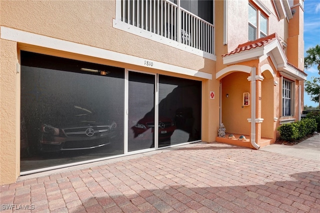 view of exterior entry featuring a balcony