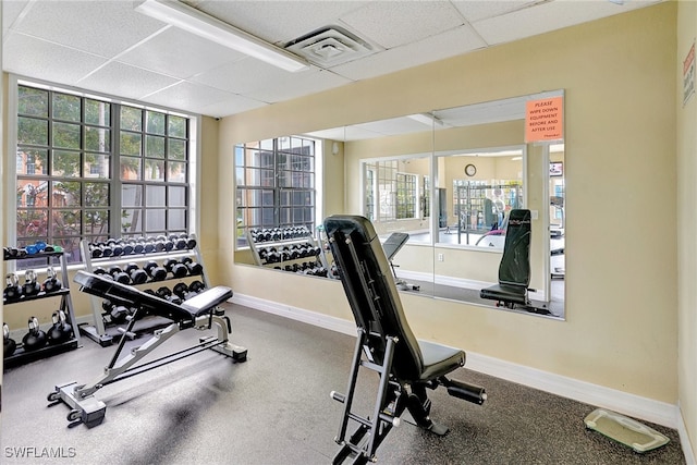 gym featuring a wealth of natural light and a drop ceiling