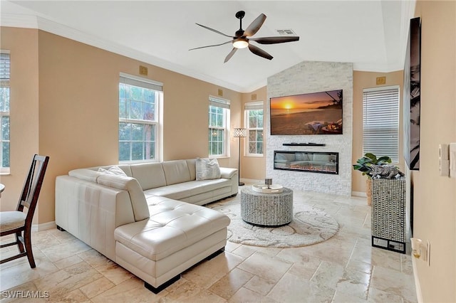 living room featuring ceiling fan, a stone fireplace, ornamental molding, and vaulted ceiling