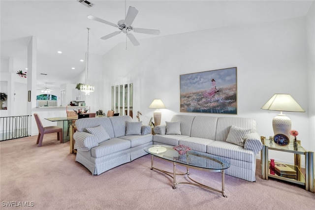 carpeted living room featuring ceiling fan with notable chandelier and high vaulted ceiling