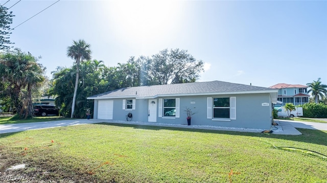 ranch-style home featuring a garage and a front lawn