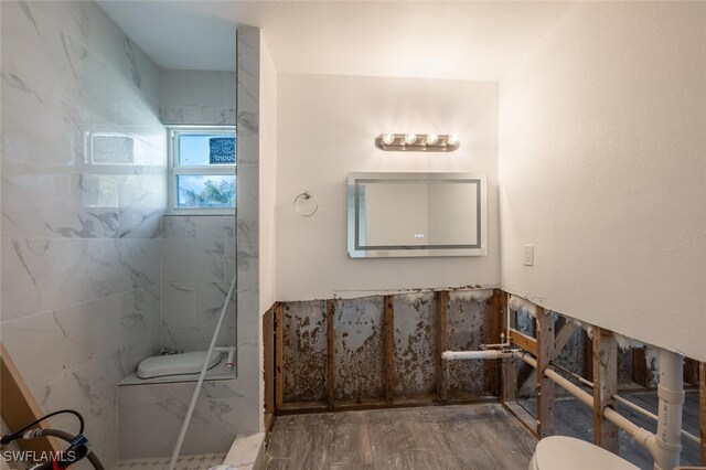 bathroom featuring toilet, hardwood / wood-style flooring, and walk in shower