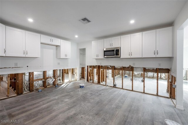 kitchen with wood-type flooring and white cabinets