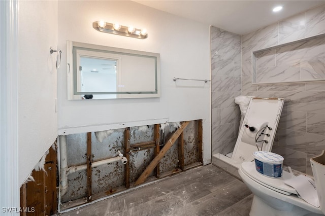 bathroom with tile walls, toilet, and walk in shower