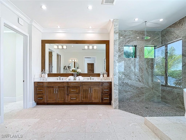 bathroom with a tile shower, vanity, and crown molding