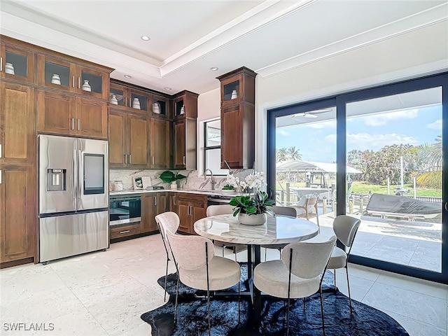 kitchen with sink, tasteful backsplash, crown molding, appliances with stainless steel finishes, and a raised ceiling