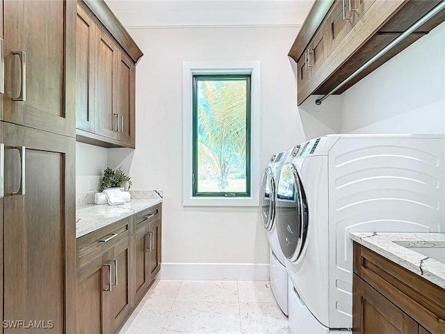 laundry room featuring cabinets and washer and clothes dryer