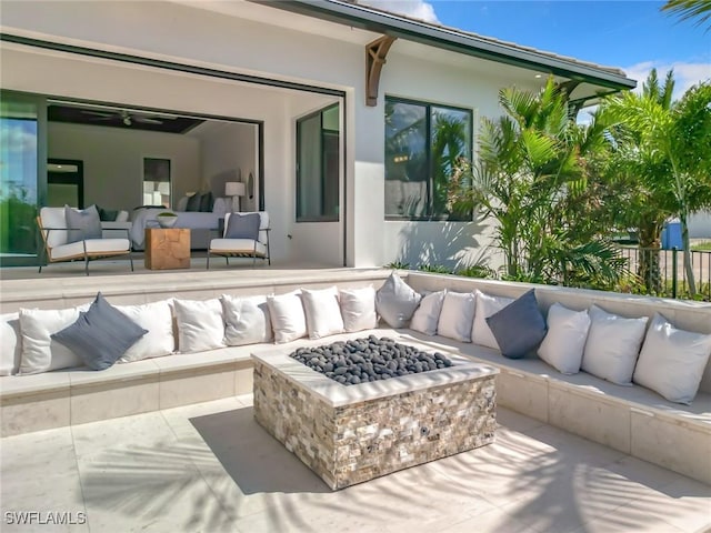 view of patio with an outdoor living space with a fire pit