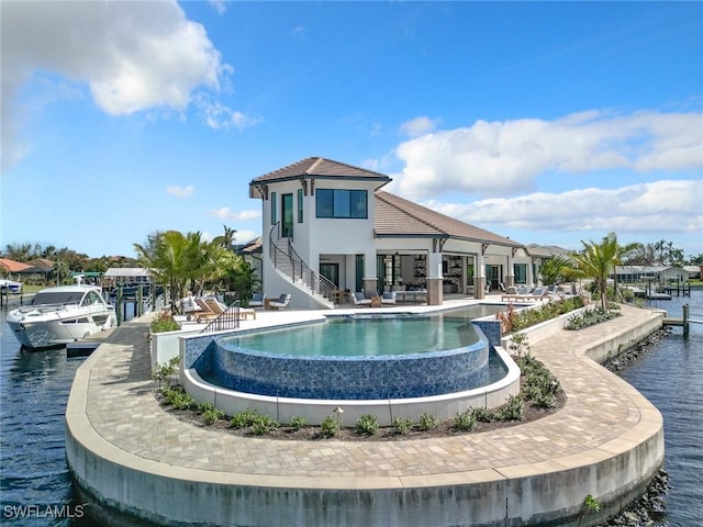 back of house with a patio and a water view