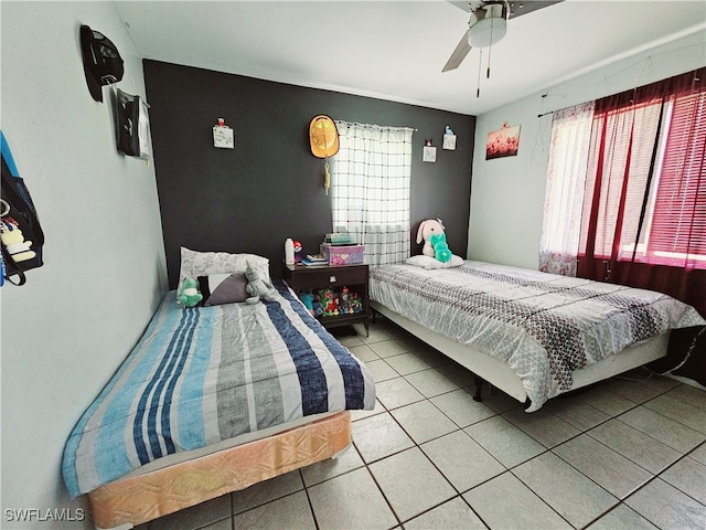 bedroom with ceiling fan, tile patterned floors, and multiple windows