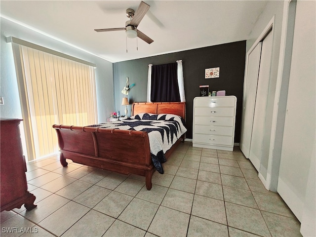 bedroom with ceiling fan, light tile patterned flooring, and a closet