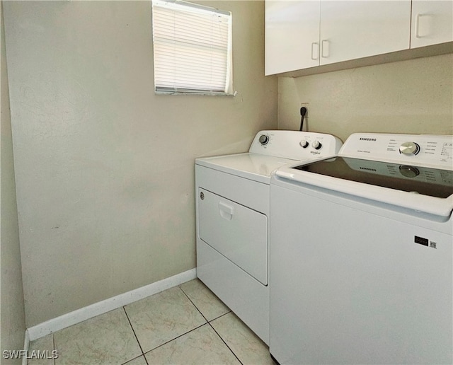 laundry area with light tile patterned flooring, independent washer and dryer, and cabinets