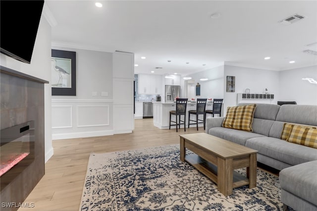 living room featuring light hardwood / wood-style floors and ornamental molding