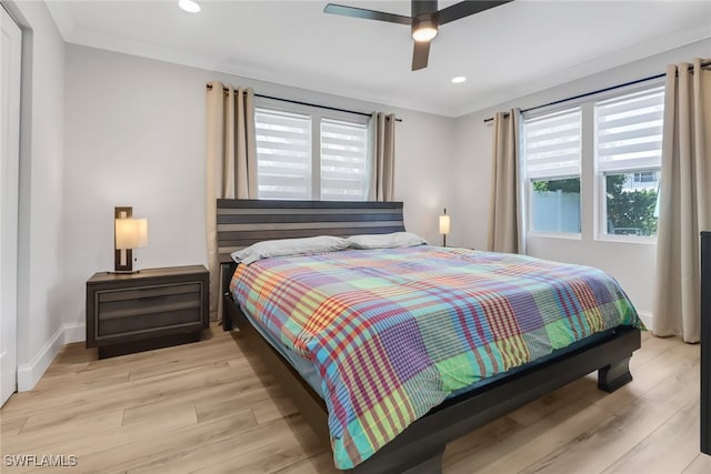 bedroom featuring light hardwood / wood-style floors, multiple windows, crown molding, and ceiling fan