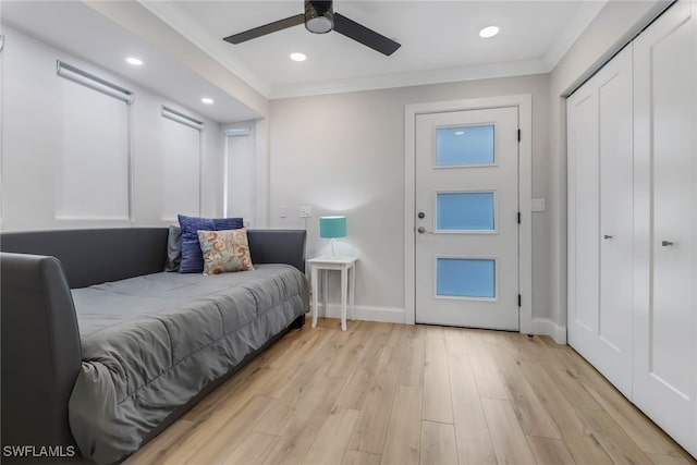 bedroom with crown molding, light hardwood / wood-style flooring, and ceiling fan