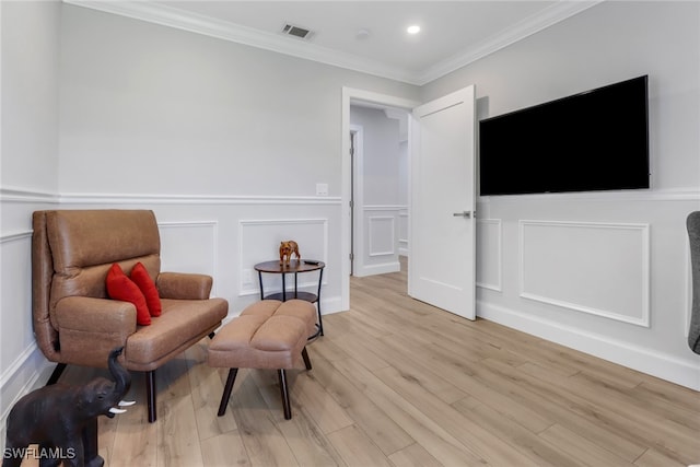 living area featuring light hardwood / wood-style floors and crown molding