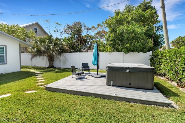 deck featuring a hot tub and a yard