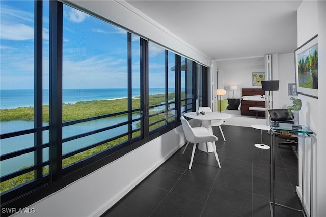 sunroom / solarium featuring a water view