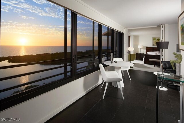 sunroom / solarium featuring a water view