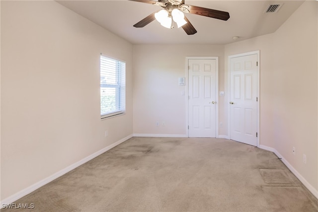 carpeted spare room featuring ceiling fan