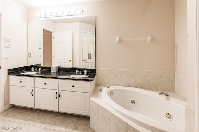 bathroom with vanity, tiled bath, and tile patterned flooring